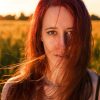 a woman with red hair in a field testimonials